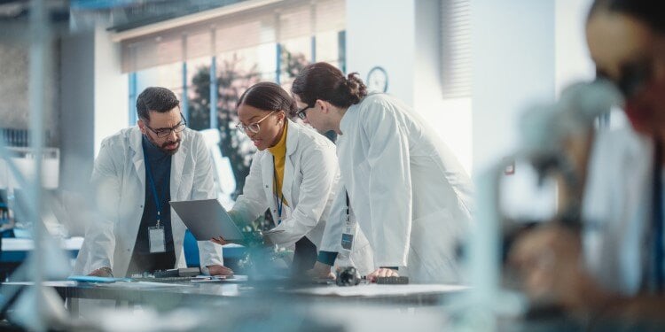 Biotech experts gathered round a lap top